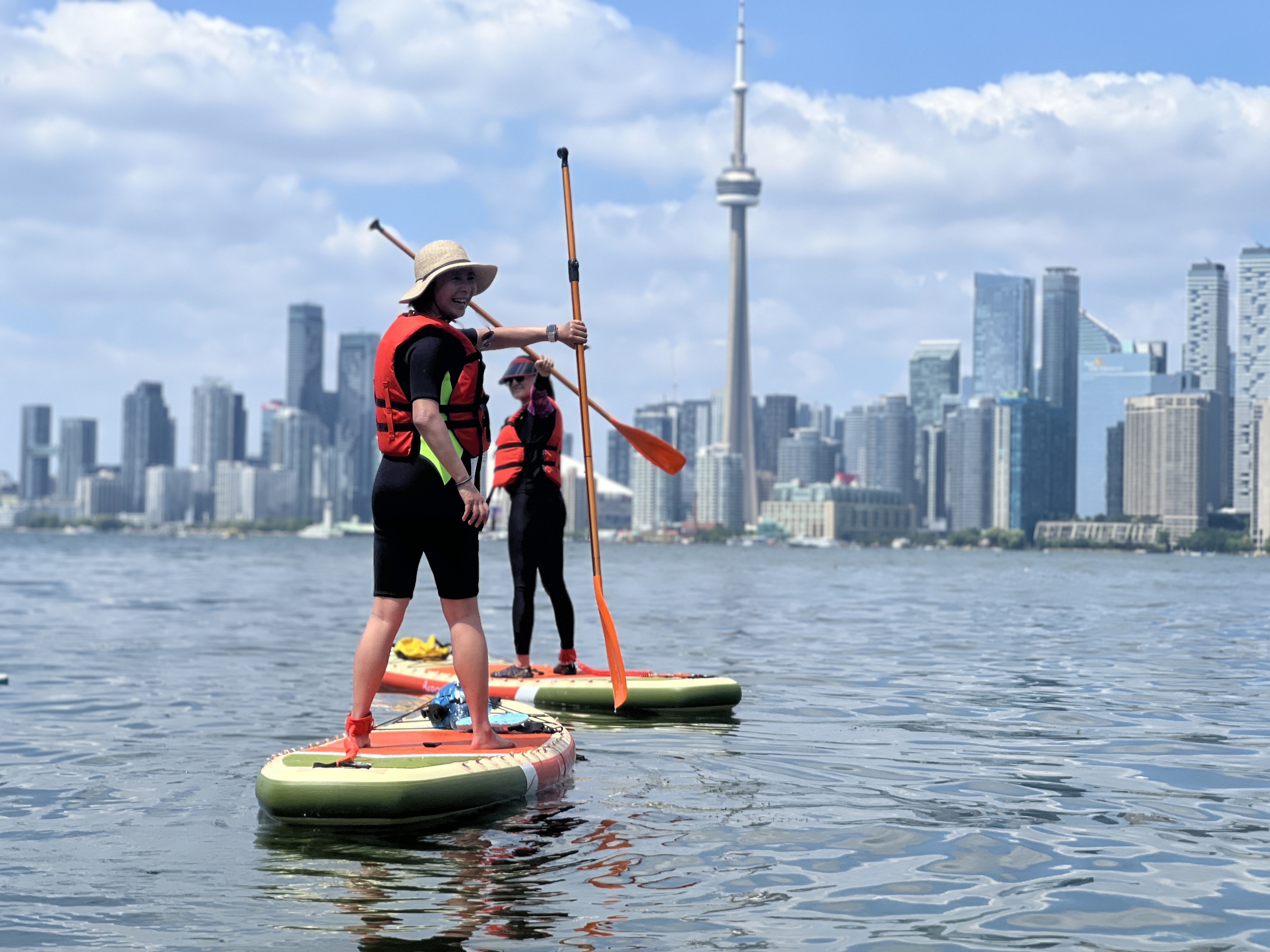 Paddlers on open water with the CN Tower and Toronto skyline behind them